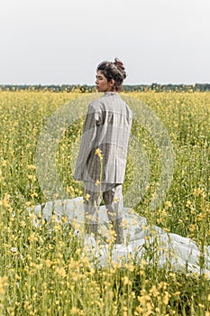 An Asian model poses in a field of yellow flowers for a clothing brand, polyethylene is the main props for a photo shoot