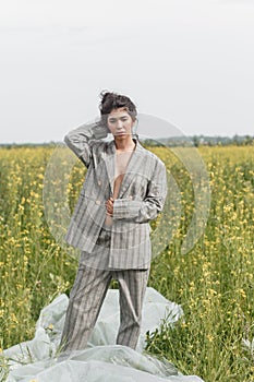 An Asian model poses in a field of yellow flowers for a clothing brand, polyethylene is the main props for a photo shoot