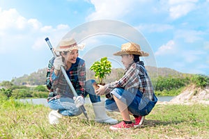 Asian Mom and child girl plant sapling tree in the nature spring for reduce global warming growth feature,