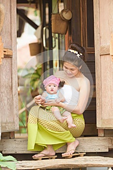 Asian mom with child in lanna suit.