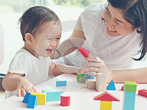 Asian mom and girl kid playing with blocks. Vintage effects and