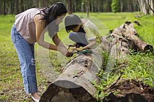 Asian Mom showing to her son something on her phone or to searching and leaning about nature