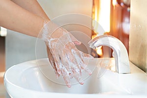 Asian Mom women wash her kid hand with soap alcohol gel for sanitizer in kitchen sink concept for prevent Hygiene health care.