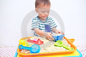 Asian 18 months / 1 year old toddler boy playing with kinetic sand at home ,Fine motor skills development, Montessori education,