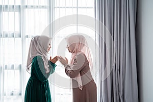 Asian moslem woman say salam when meeting her friend