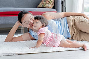 Asian mother and 7-month-old daughter sitting on the floor they are relaxation and happy together