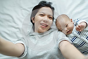 Asian mother and baby son having video call