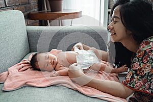 Asian mother change diaper to her little daughter