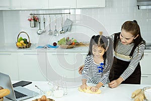 Asian mother and child cook from flour in kitchen,leisure activity at home