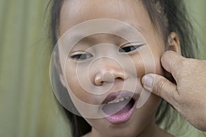 Asian mother and child girl playing pinch cheeks, touch nose funny face