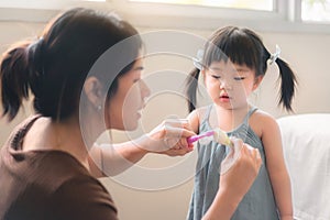 Asian mother and daughter brushing their teeth together, Mom teaching his daughter how to brush teeth, Oral health concept