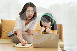 Asian mother and daughter kid using smartphone at home