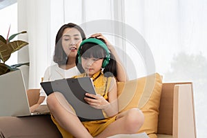 Asian mother and daughter kid using smartphone at home