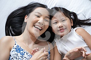 Asian mother and daughter smile and look at camera. Happy love family concept.