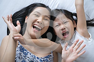 Asian mother and daughter smile and look at camera. Happy love family concept