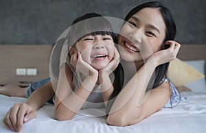 Asian mother and daughter smile and look at camera. Happy love family concept.