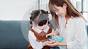 Asian mother and daughter washing hands with alcohol gel or antibacterial soap sanitizer at home , Mom teach child how to wash