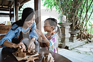 Asian mother and daughter working with clay