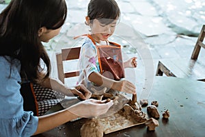 Asian mother and daughter working with clay