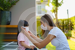 Asian mother help her daughter wearing protection mask to protect the coronavirus Covid-19 outbreak situation before go to school