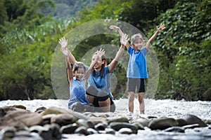 Asian mother and her daughters playing in the river together with fun