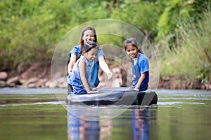Asian mother and her daughters playing in the river together with fun
