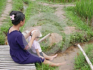 Asian mother and her little baby girl enjoy spending time together in a rice field