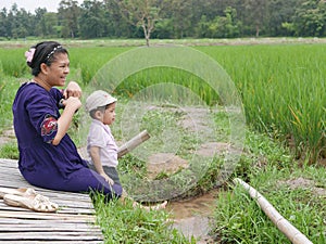 Asian mother and her little baby girl enjoy spending time together in a rice field