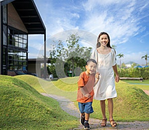 Asian mother and her som running togather on the garden