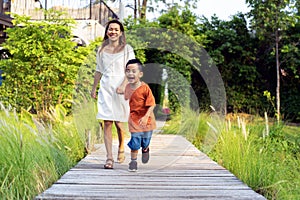 Asian mother and her som running togather on the garden