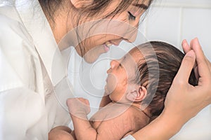 Asian mother holding her infant baby boy on hands