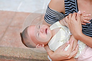 Asian mother holding screaming newborn baby boy