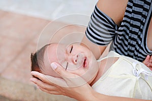 Asian mother holding screaming newborn baby boy