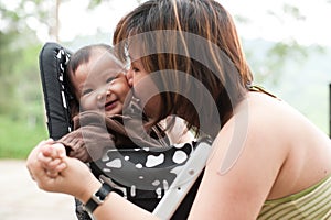 Asian mother kissing her 7 month old baby girl