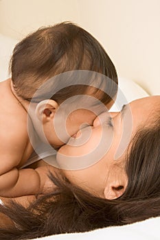 Asian mother kissing her baby boy son