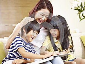 Asian mother reading story to two children