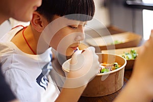 Asian mother & son have lunch in a restaurant