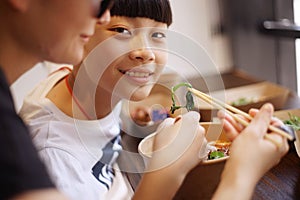 Asian mother & son have lunch in a restaurant