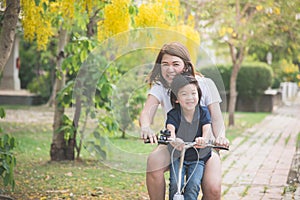 Asian mother and son riding bicycle