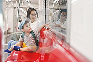 Asian mother and son traveling by commuter train