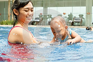 Asian mother teach baby to swim