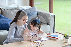 Asian mother teaching her cute kid daughter to studying