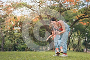 Asian mother walking with daughter in park, Happy family in the park evening light