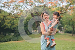 Asian mother walking with daughter in park, Parents hold the baby\'s in his hand