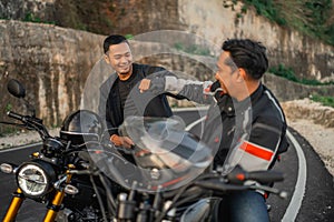 asian motorcyclist sitting motorbike fist bump gesture