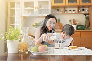 Asian mum and daughter share their breakfast.