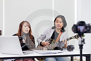 Asian musician performing rock show live at home using online platform for fan and audience at home concert and streaming