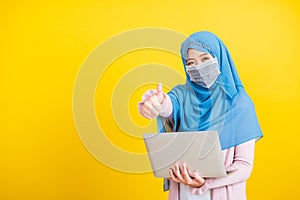 Asian Muslim Arab, woman Islam religious wear veil hijab and face mask protect she quarantines coronavirus hold laptop computer