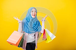 Asian Muslim Arab woman Islam wear hijab she holding colorful shopping bags so glad