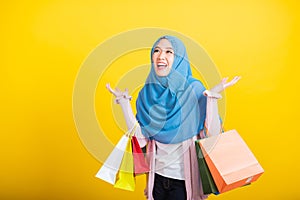 Asian Muslim Arab woman Islam wear hijab she holding colorful shopping bags so glad